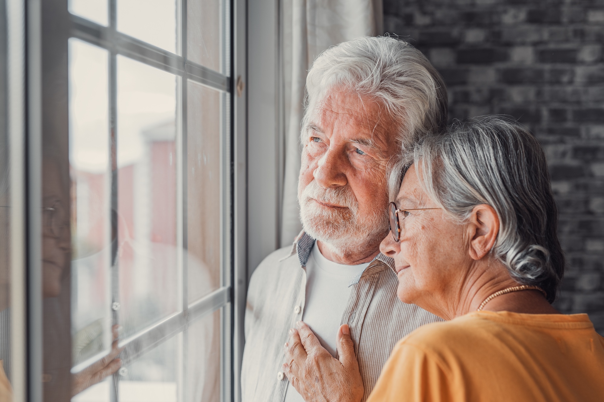 Älteres Paar schaut gemeinsam aus dem Fenster und lehnt sich eng aneinander, Beispielfoto für Alzheimer / Demenz, Neurologische Praxis Dr. Hartmut Bauer, Euskirchen Älteres Paar schaut gemeinsam aus dem Fenster und lehnt sich eng aneinander, Beispielfoto für Alzheimer / Demenz, Neurologische Praxis Dr. Hartmut Bauer, Euskirchen