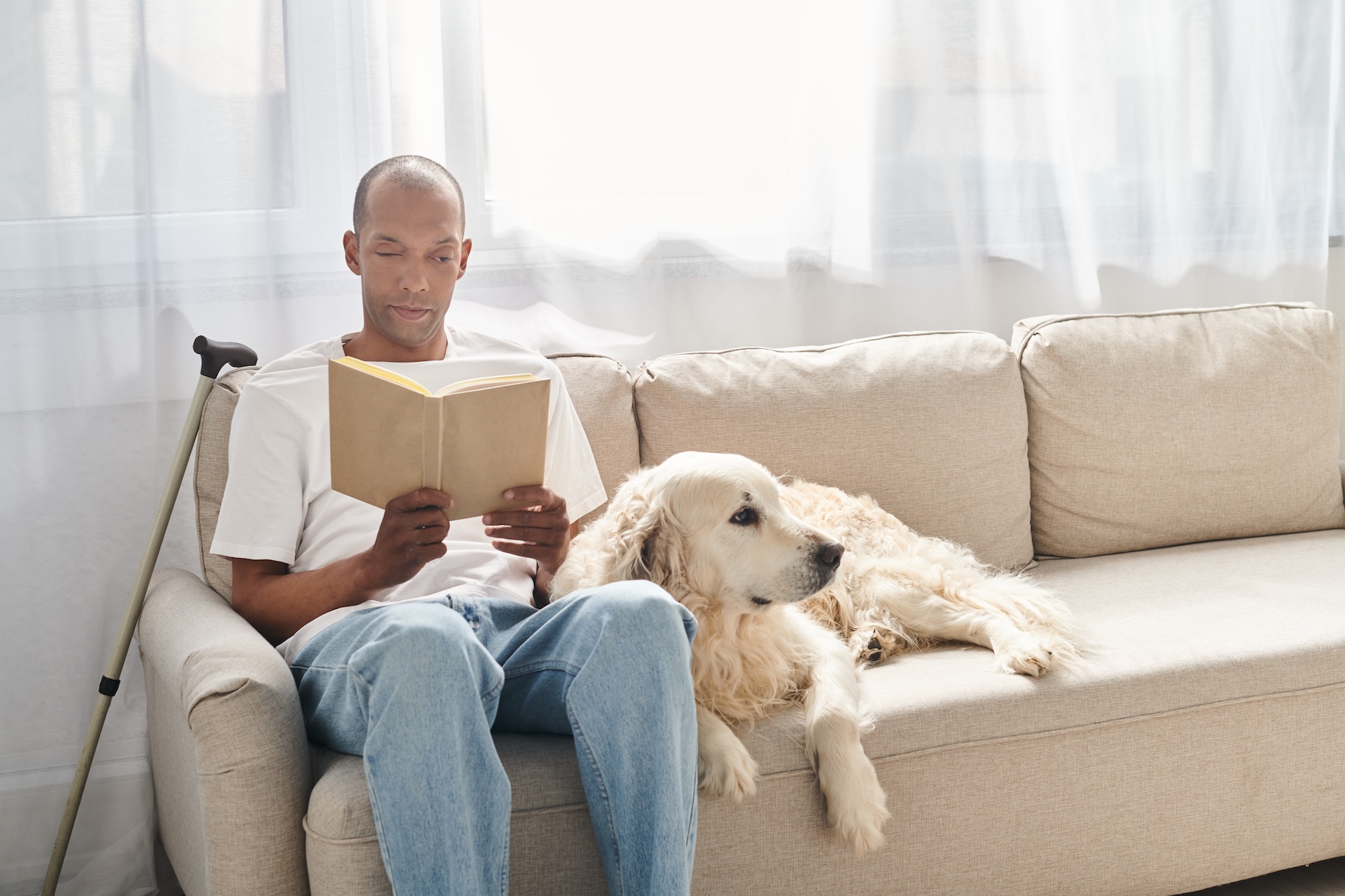Junger Mann sitzt auf der hellen Couch und liest ein Buch, sein Hund liegt neben ihm. Beispielfoto für Myasthenie, myotone Dystrophie / andere Muskelerkrankungen, Neurologische Praxis Dr. Hartmut Bauer, Euskirchen Junger Mann sitzt auf der hellen Couch und liest ein Buch, sein Hund liegt neben ihm. Beispielfoto für Myasthenie, myotone Dystrophie / andere Muskelerkrankungen, Neurologische Praxis Dr. Hartmut Bauer, Euskirchen