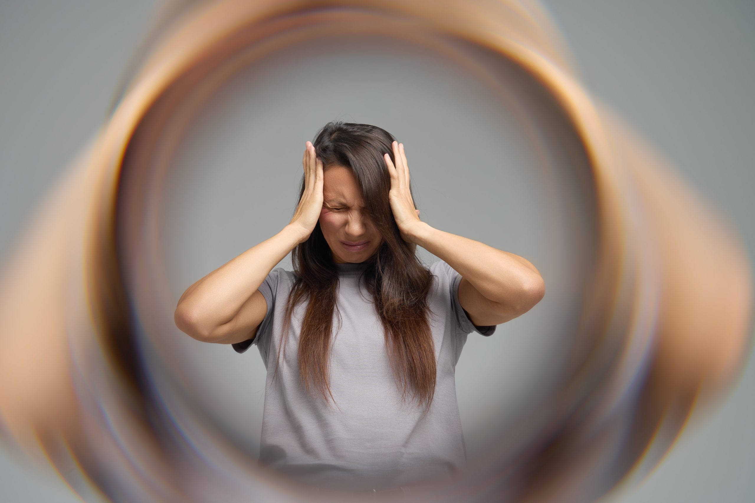 Junge Frau hält sich die Stirn und hat eine Aura wegen Migräne-Anfall, Neurologische Praxis Dr. Hartmut Bauer, Euskirchen