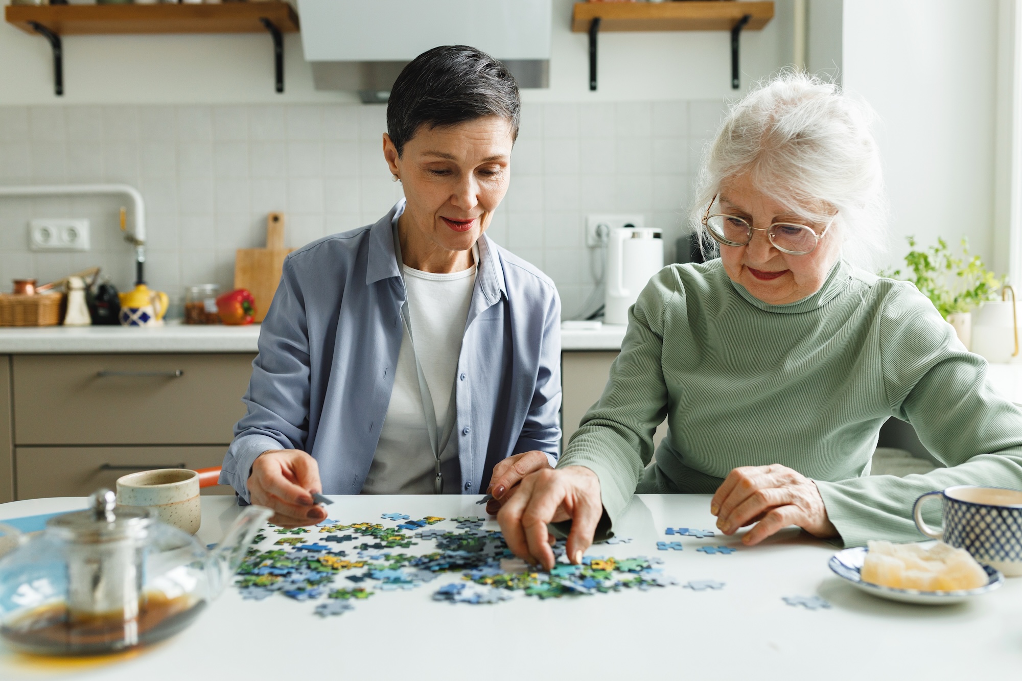 Zwei Frauen in der Küche beim Puzzlespiel, Beispielfoto für Alzheimer / Demenz-Erkrankung, Neurologische Praxis Dr. Hartmut Bauer, Euskirchen Zwei Frauen in der Küche beim Puzzlespiel, Beispielfoto für Alzheimer / Demenz-Erkrankung, Neurologische Praxis Dr. Hartmut Bauer, Euskirchen